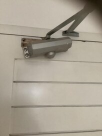 Door closer hanging off, screws missing