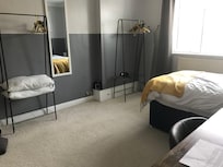 Dorm room chic with flimsy racks and cheap back of door mirror
