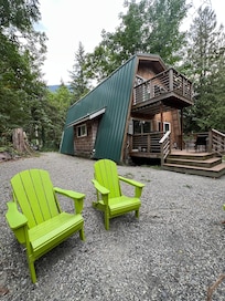 Back of cabin, chairs by the fire pit.