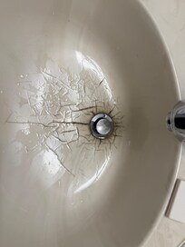Cracked, dirty bathroom sink.