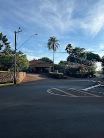 Do outro lado da rua, a vista revela uma paisagem tranquila, com árvores bem-cuidadas, natureza ao redor e um charme acolhedor que convida ao descanso. Um cenário perfeito para quem busca sossego e contato com o ambiente ao ar livre.