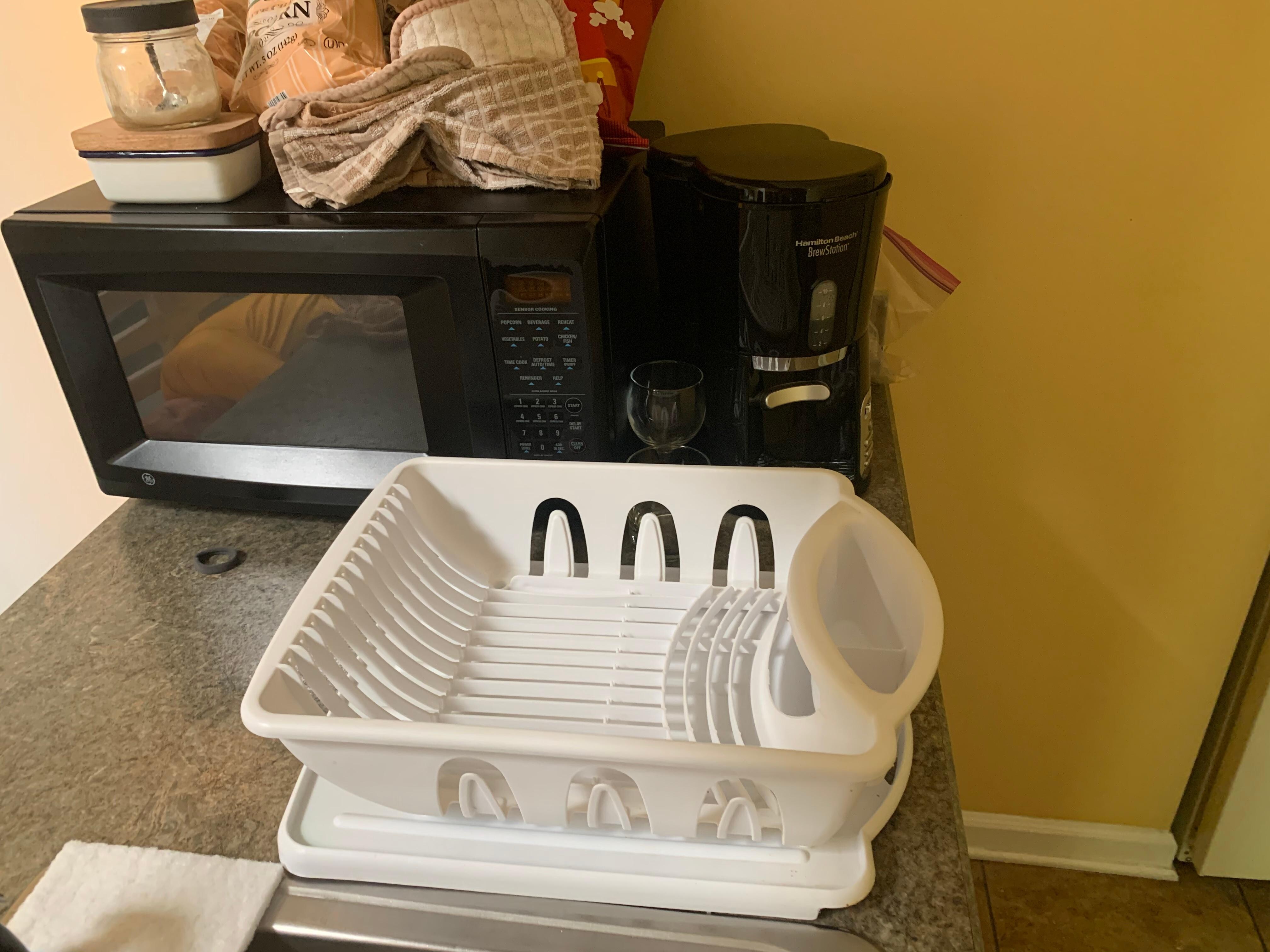 Microwave and coffee pot squeezed next to the sink makes it hard to do dishes 