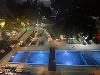 Blick vom Balkon auf den Pool und die Straße