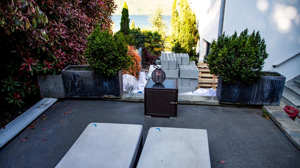 Terrasse de la chambre. Le sol et le mobilier sont sales. La petite vue est cachée par les parpaings. La route est juste derrière avec les voitures qui passent juste au dessus.