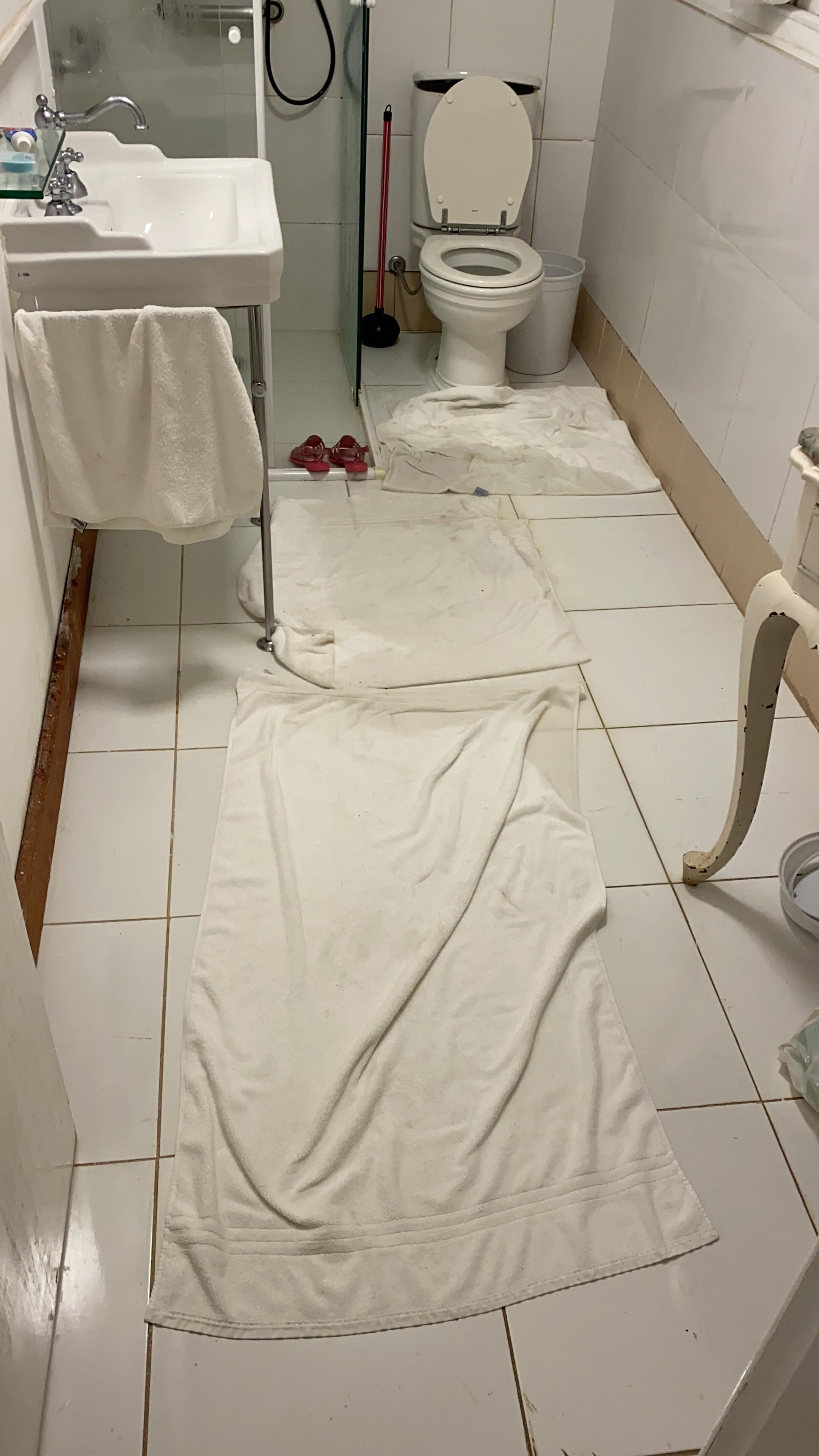 Toalhas no chão para tentar conter Vazamento e entupimento do banheiro da suíte Alecrim