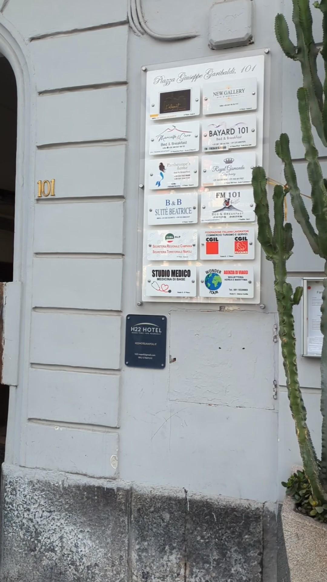 The easily missed sign for the hotel. Enter through the door to the left of the sign board. Take the first left to the end of the corridor. Go up stairway D on the left to the second floor.