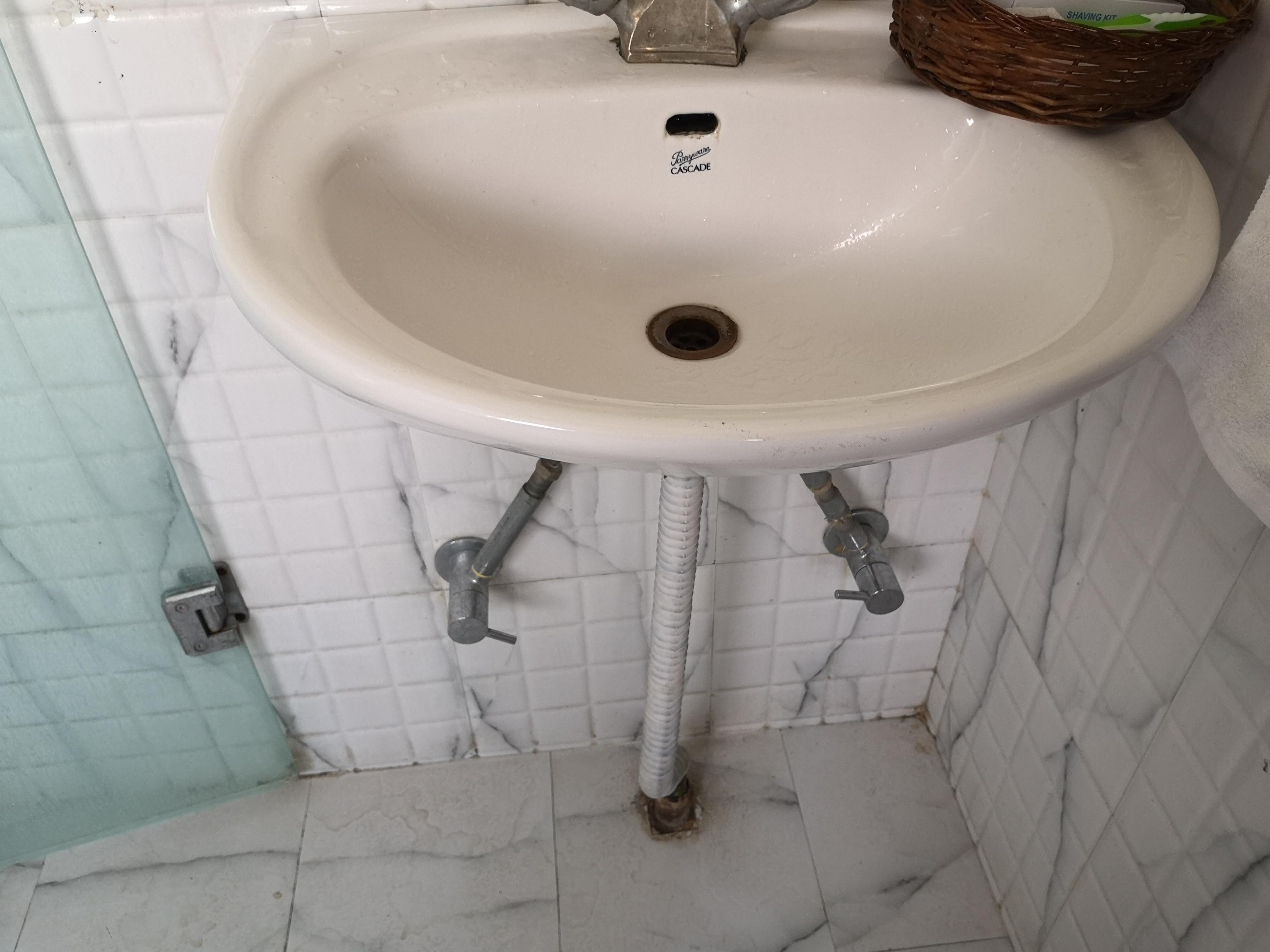 Wash basin in a luxury apartment with rust moulds on the pipe.  Hot water never worked.  