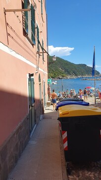 Links das Haus mit der Wohnung im ersten Stock, direkt daneben der Strand.