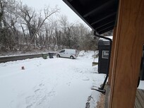 View of the front yard covered in snow and ice from the front porch.