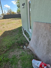 at rear bedroom egress door, plywood, 2x4 lumber, trash