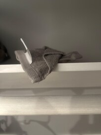 Dirty towel in closet on shelf.