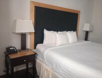 Bed has tables and lamps on both sides.