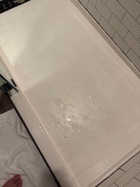 Some sort of black crumbs in shower base