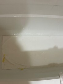 They placed a piece of vinyl over the holes in the tub