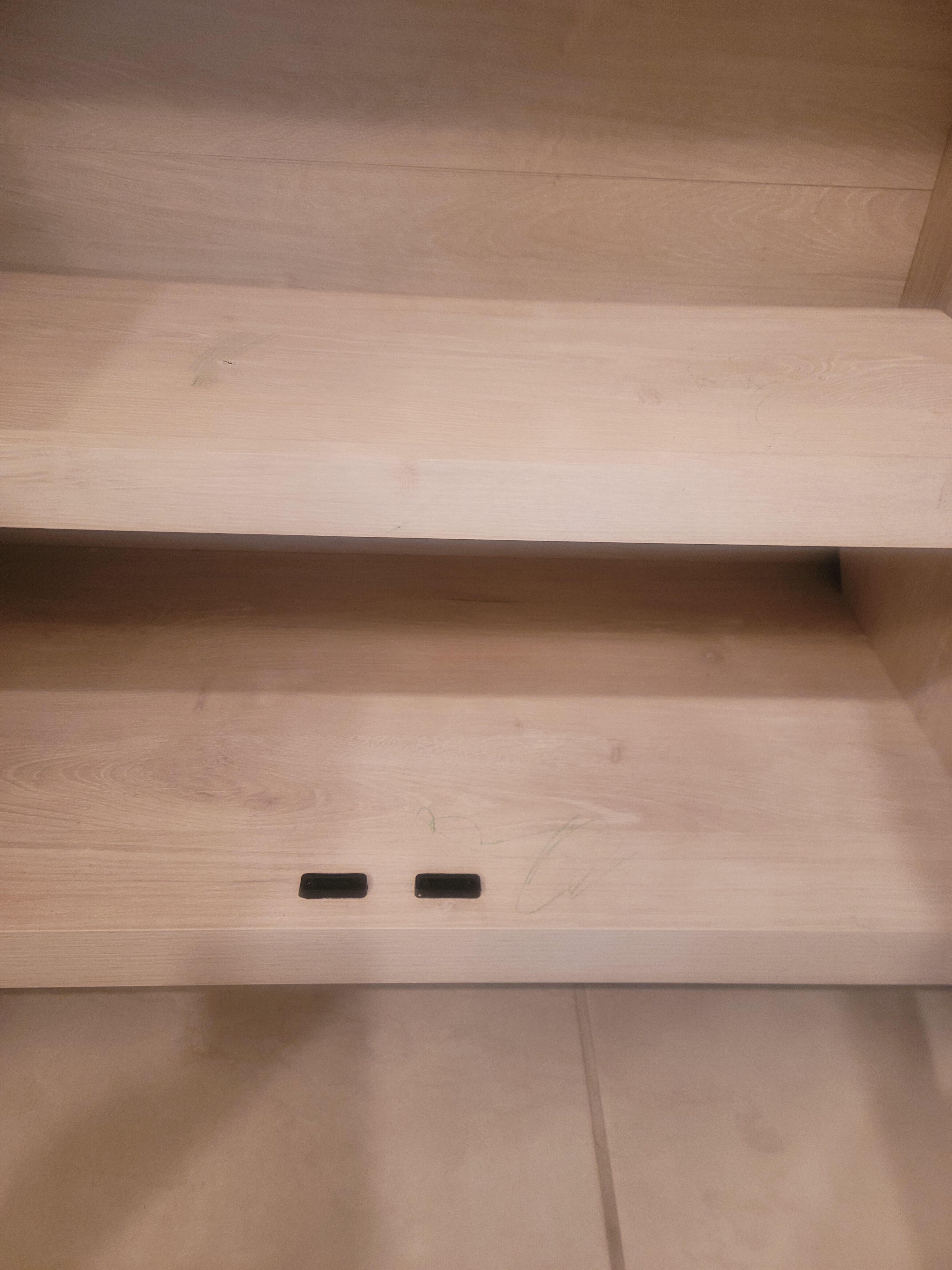 Someone draw with a crayon or marker on shelves 