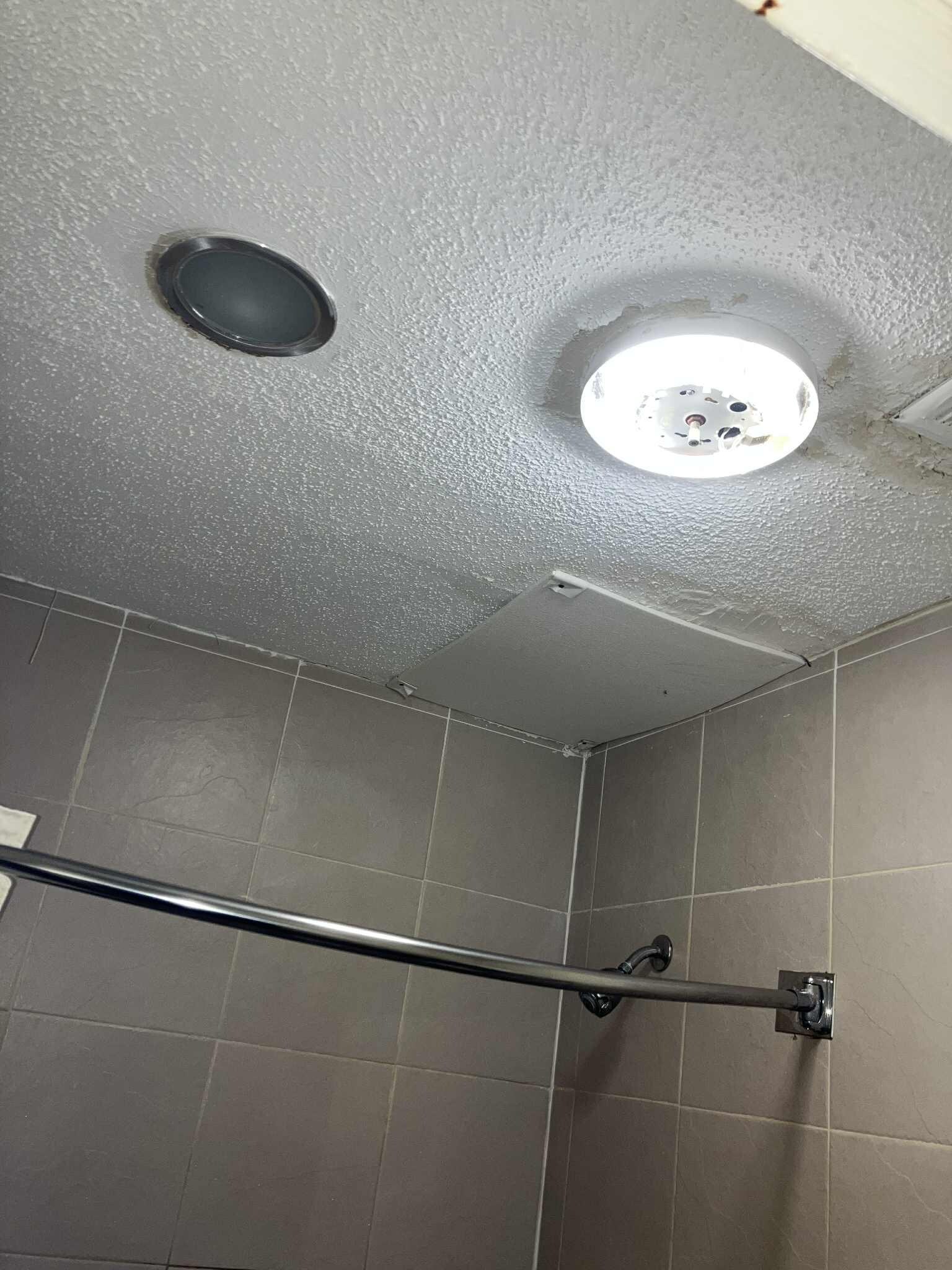 Bathroom light fixture broken and exposed light. Mold on ceiling.