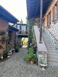 Alley between garage and main house with stairs and upper walkway to Lucca room