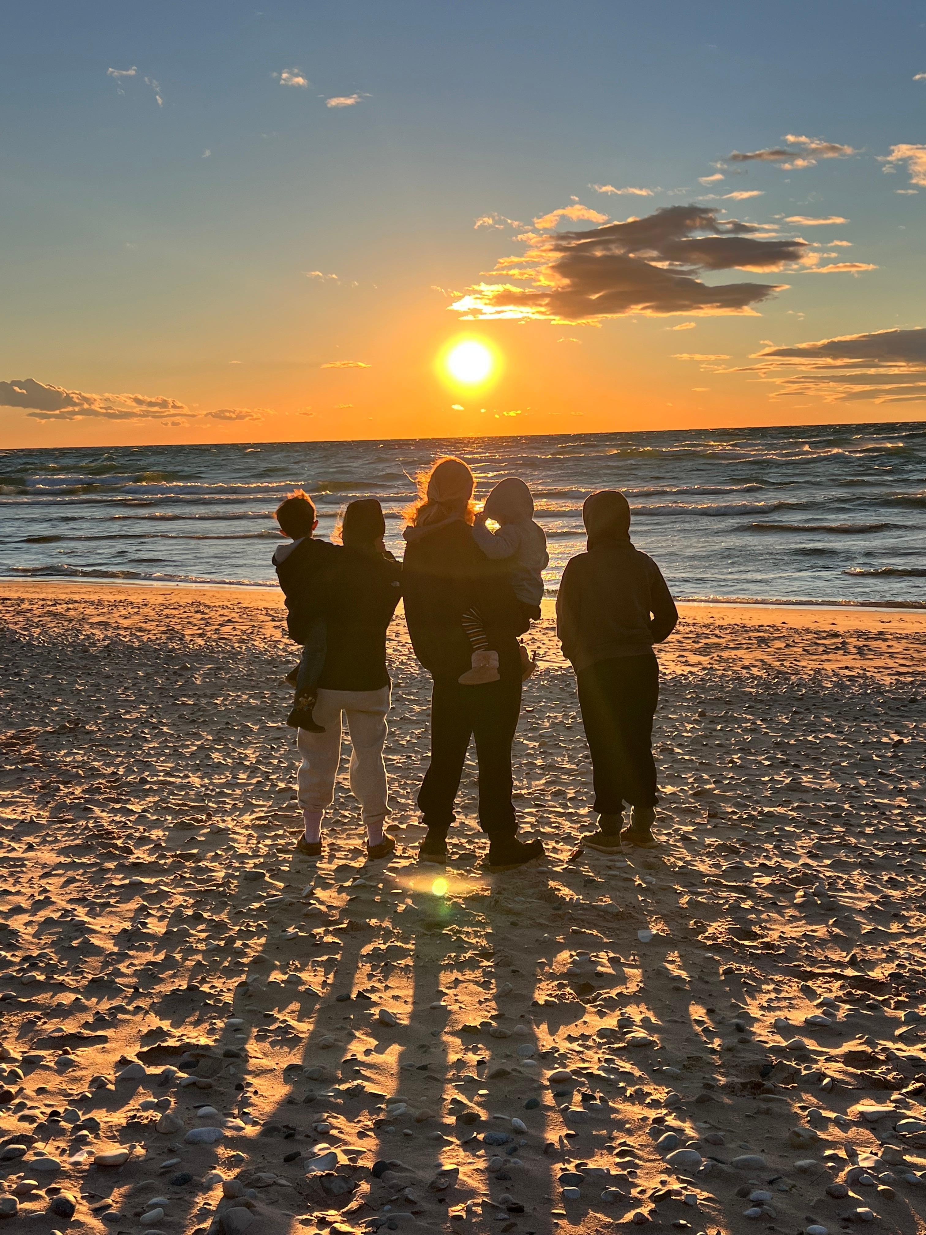 Family watching the sunset and playing at the beach