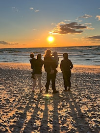 Family watching the sunset and playing at the beach