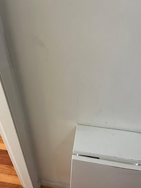 Marks on the wall next to the table in the living room