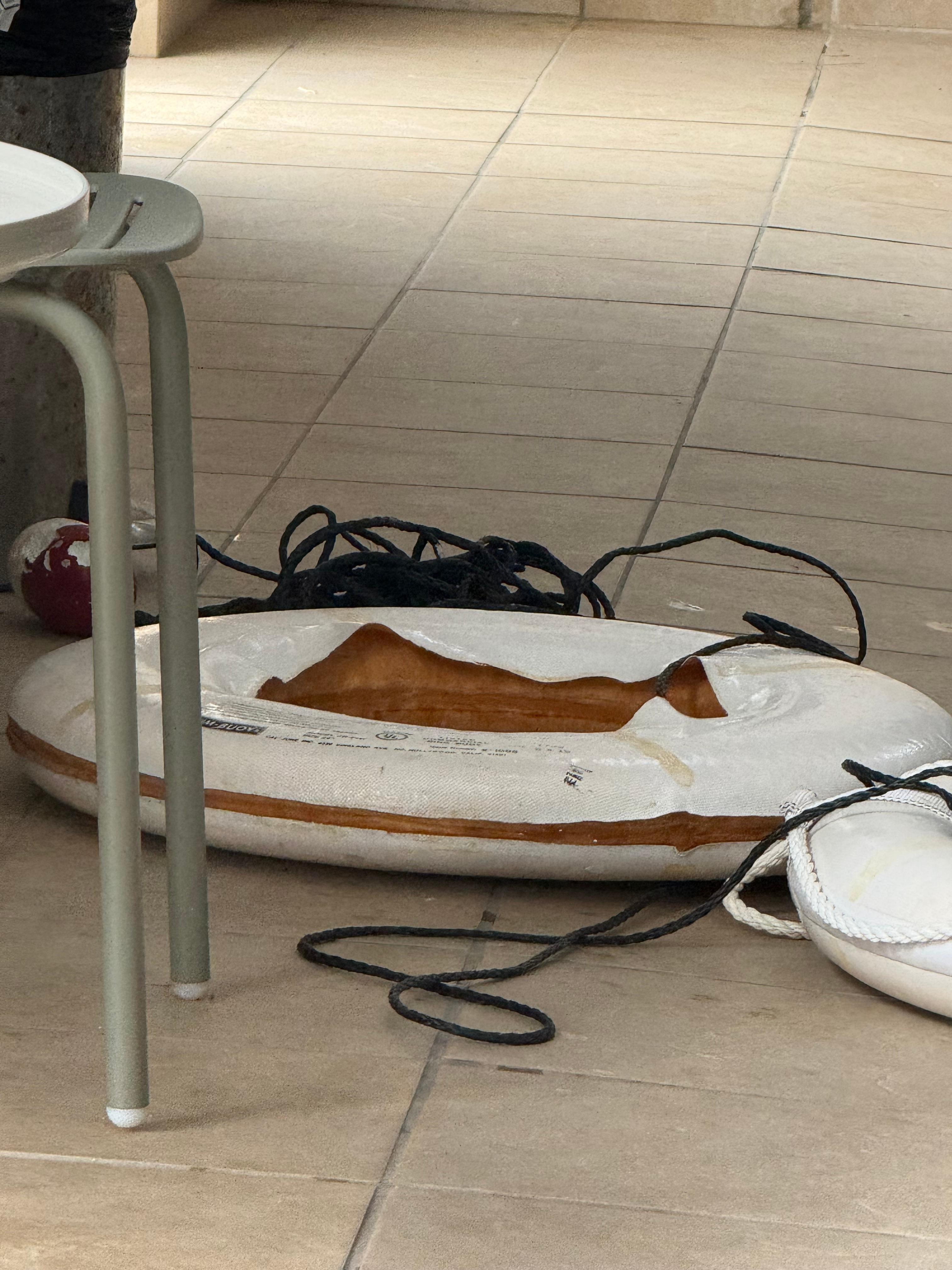 Severely damage lifesaver just left on the floor, where anyone could easily trip over it
