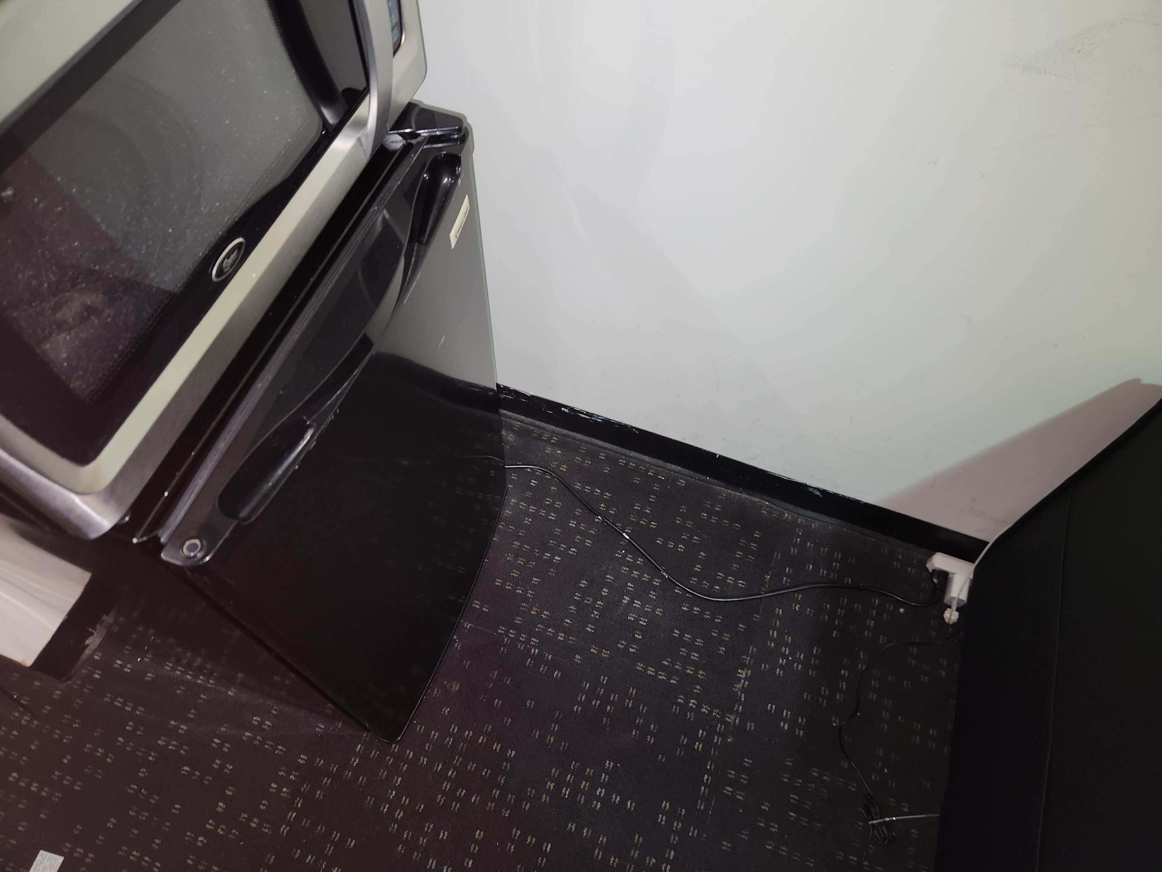 mini fridge plugged into extension cords in the room