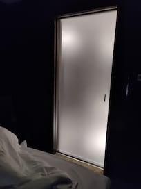 Hell erleuchtete Badtür direkt neben dem Bett.