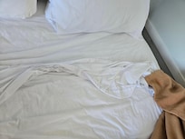 The sheets were found this way under the disheveled blanket, all hidden under a well stained comforter.