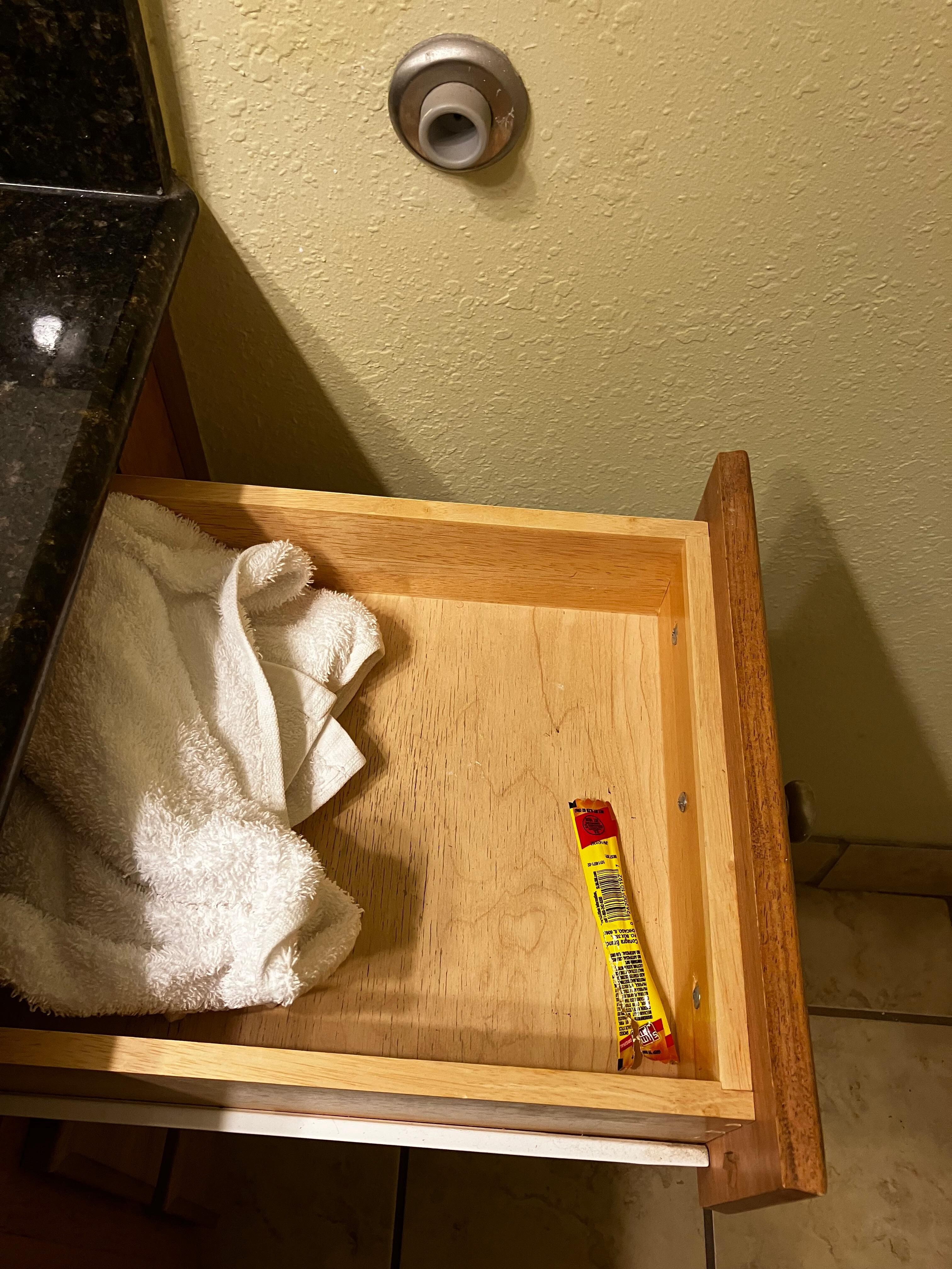 Dirty towel and Slim Jim wrapper in the bathroom drawer
