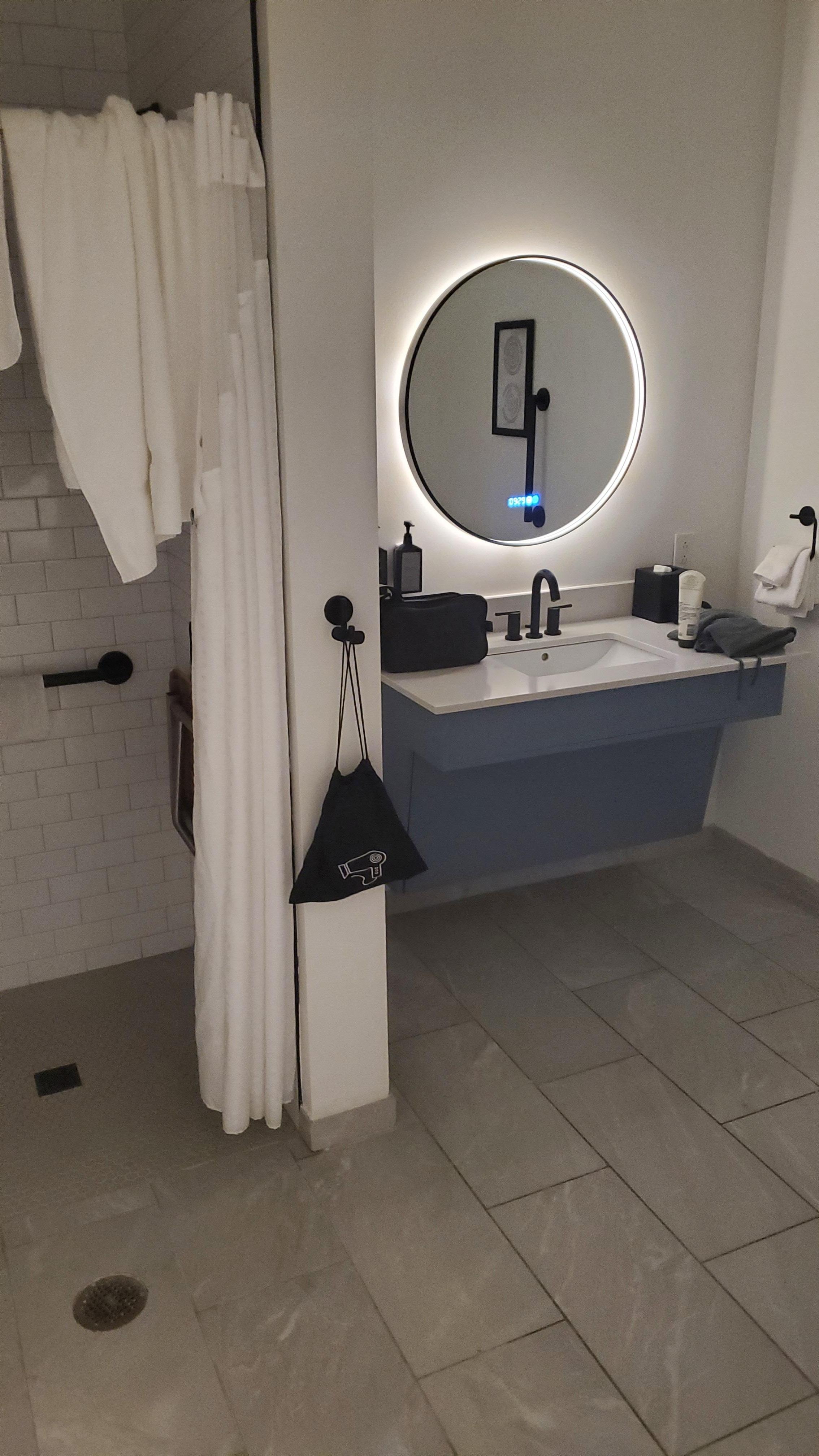 Bathroom with nice walk in shower and cool mirror