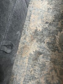 One of at least a dozen stains on this rug, also shows in the background a different couch than advertised in the listing
