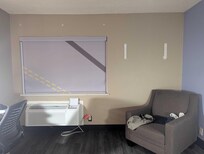Missing curtains, patched areas, and holes in the wall.