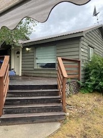 Ouside in disrepair, steps and deck old and worn as is siding