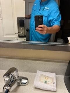 multiple colors of toothpaste on mirror and toothpaste spots on mirror