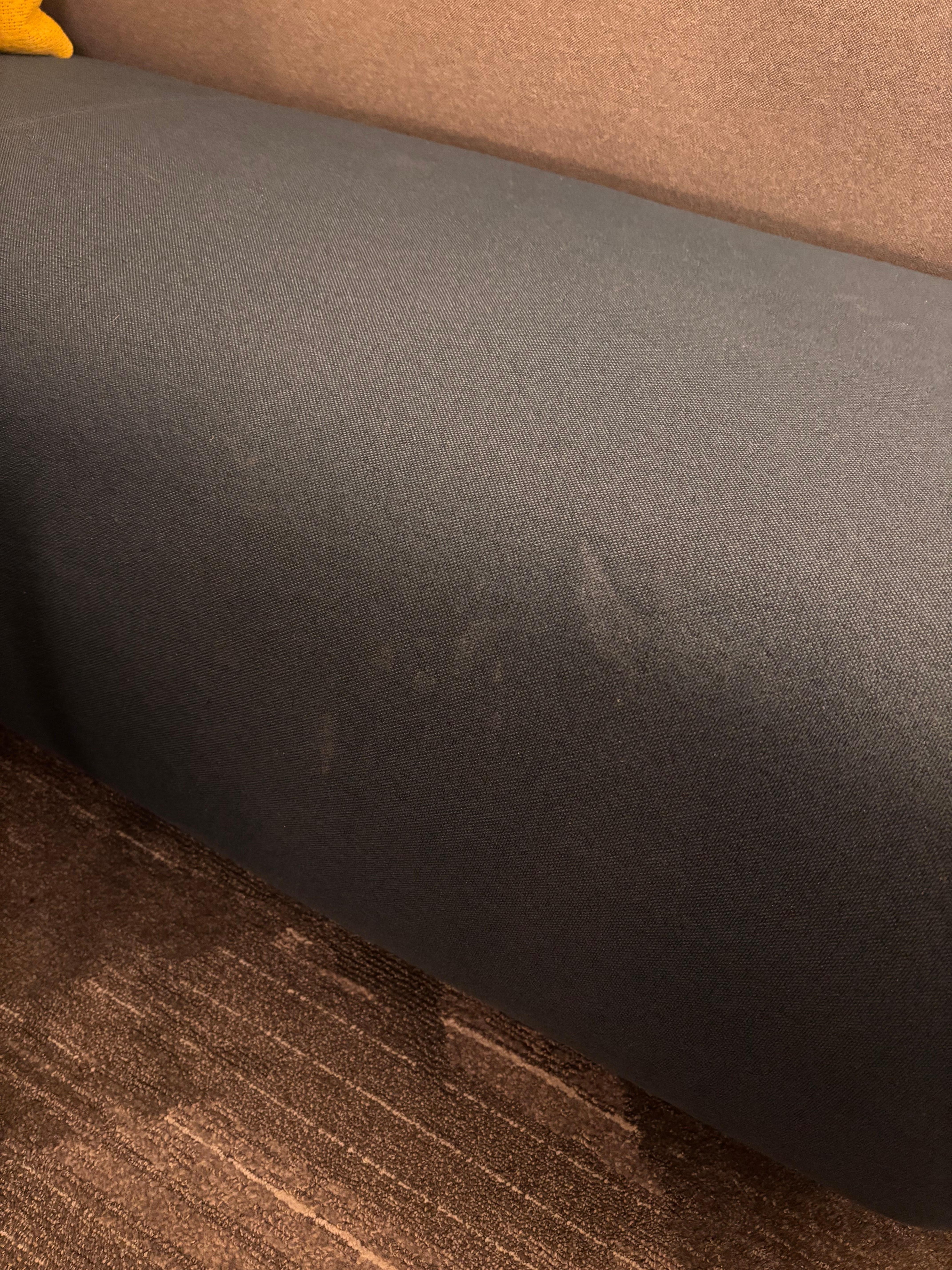 Nasty questionable stains on sofa in room. 