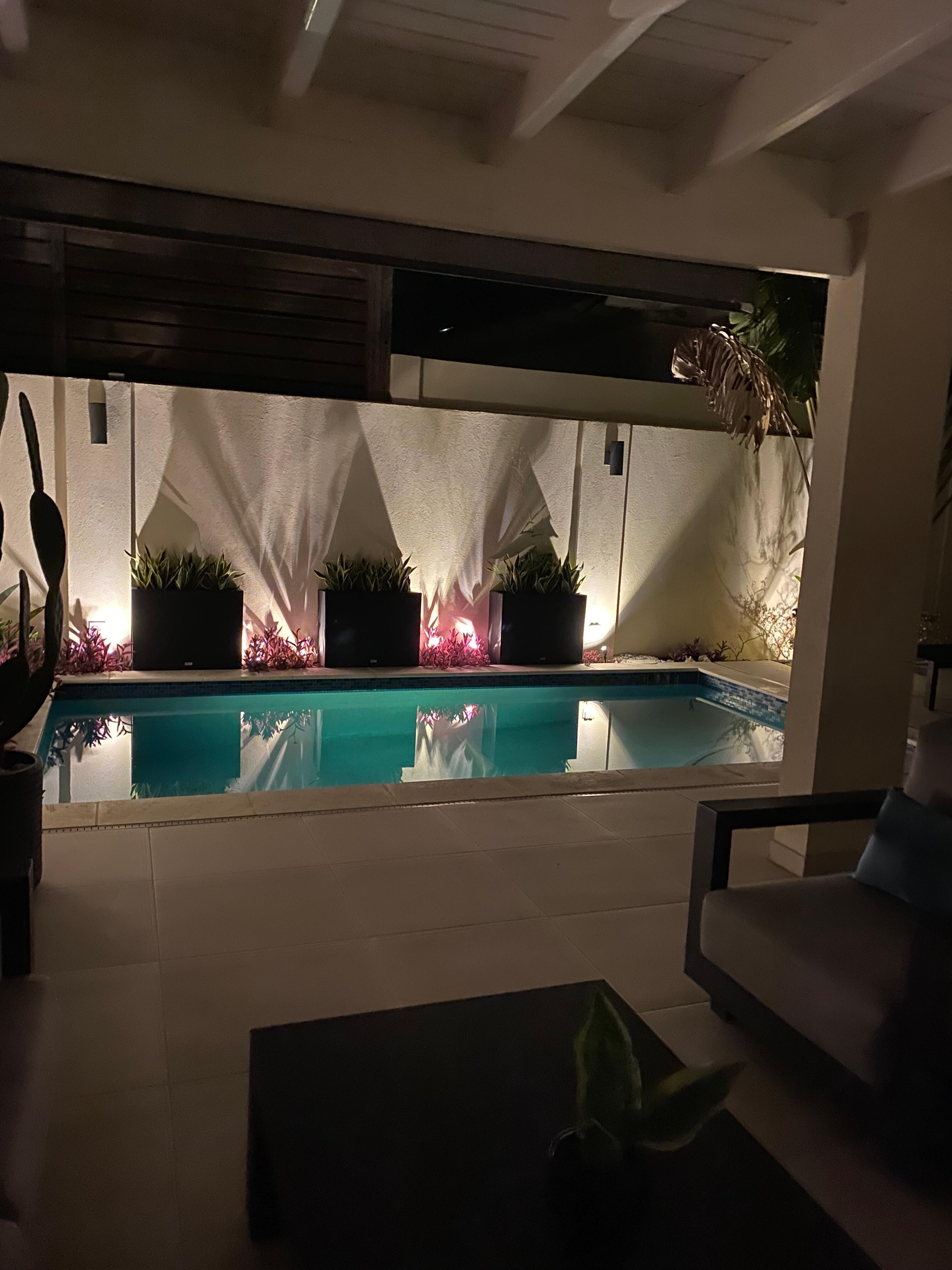 Pool at night from inside living room.  