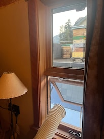 Our only view of bee brood boxes on the rooftop next door with the AC vent attached to the plexiglass.
