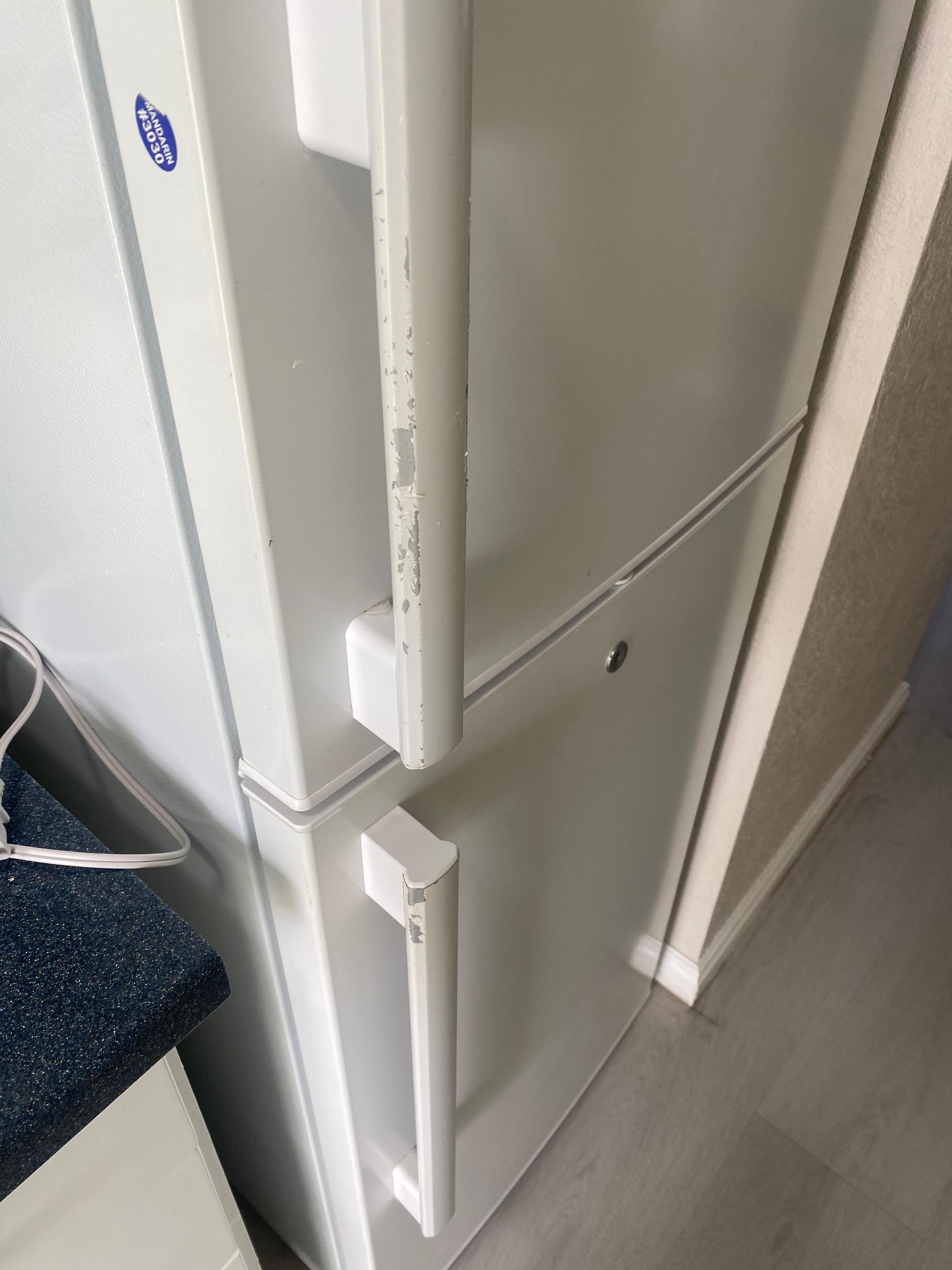 Peeling paint on door of fridge.