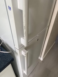 Peeling paint on door of fridge.