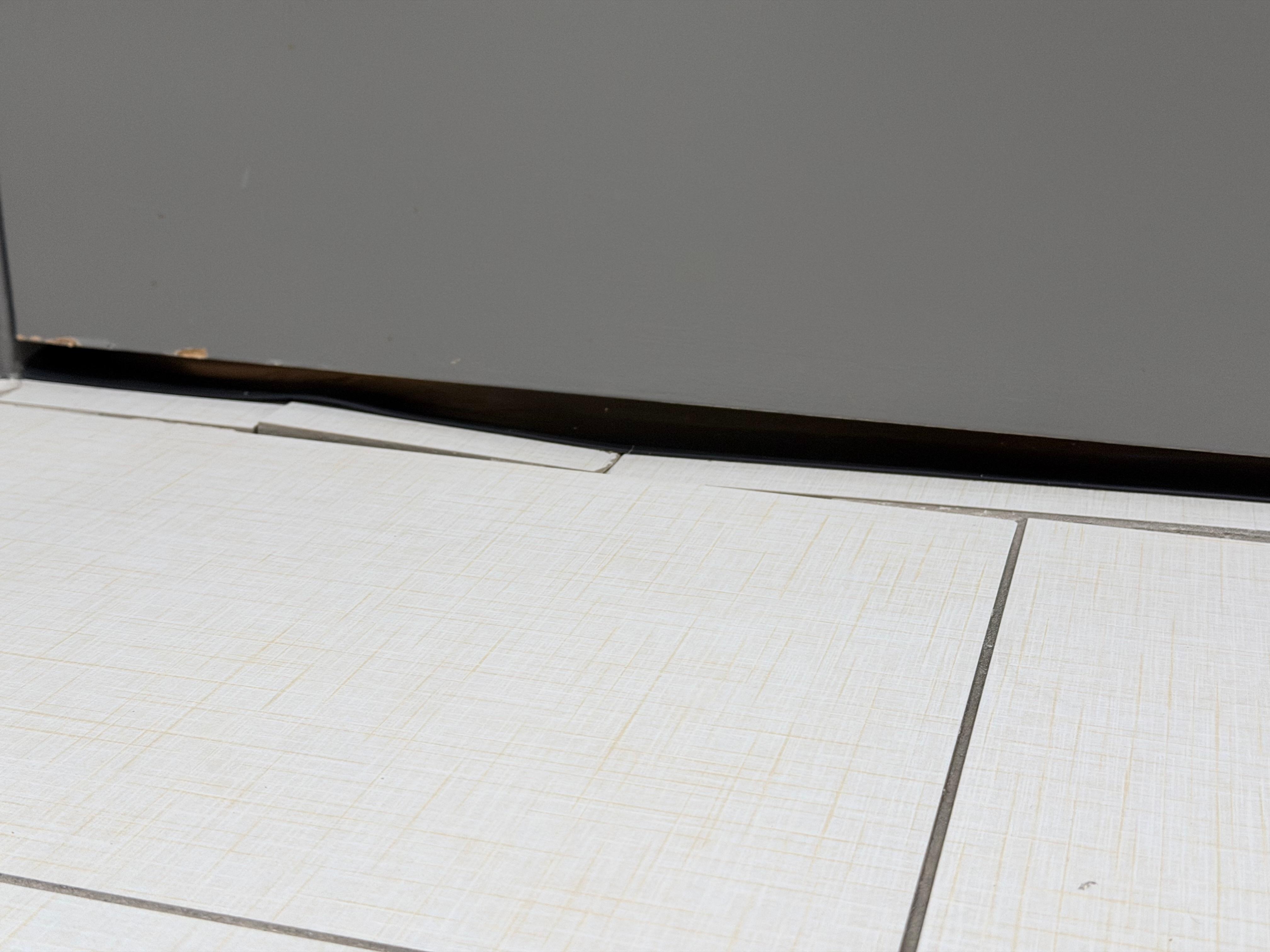 Other side where tile is coming also broken free in bathroom.