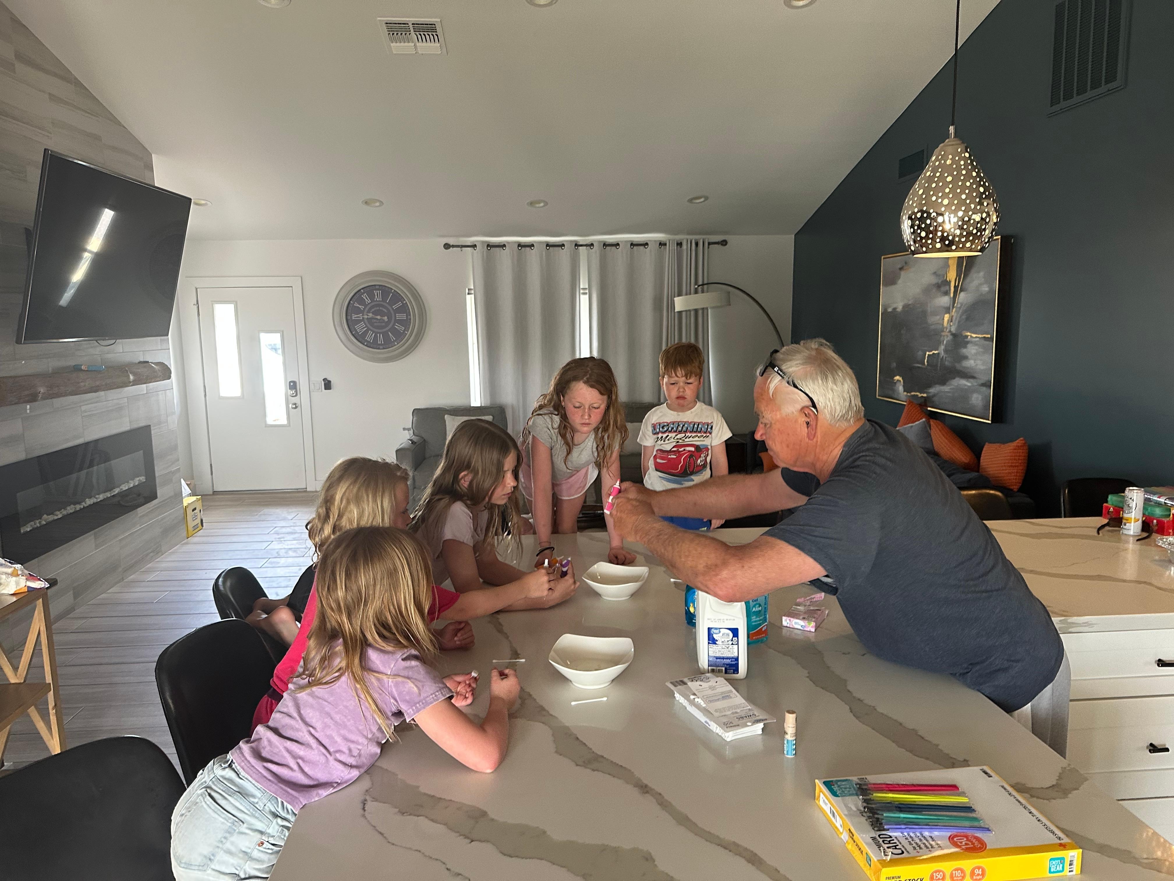 Papa leading kiddos through a science experiment!