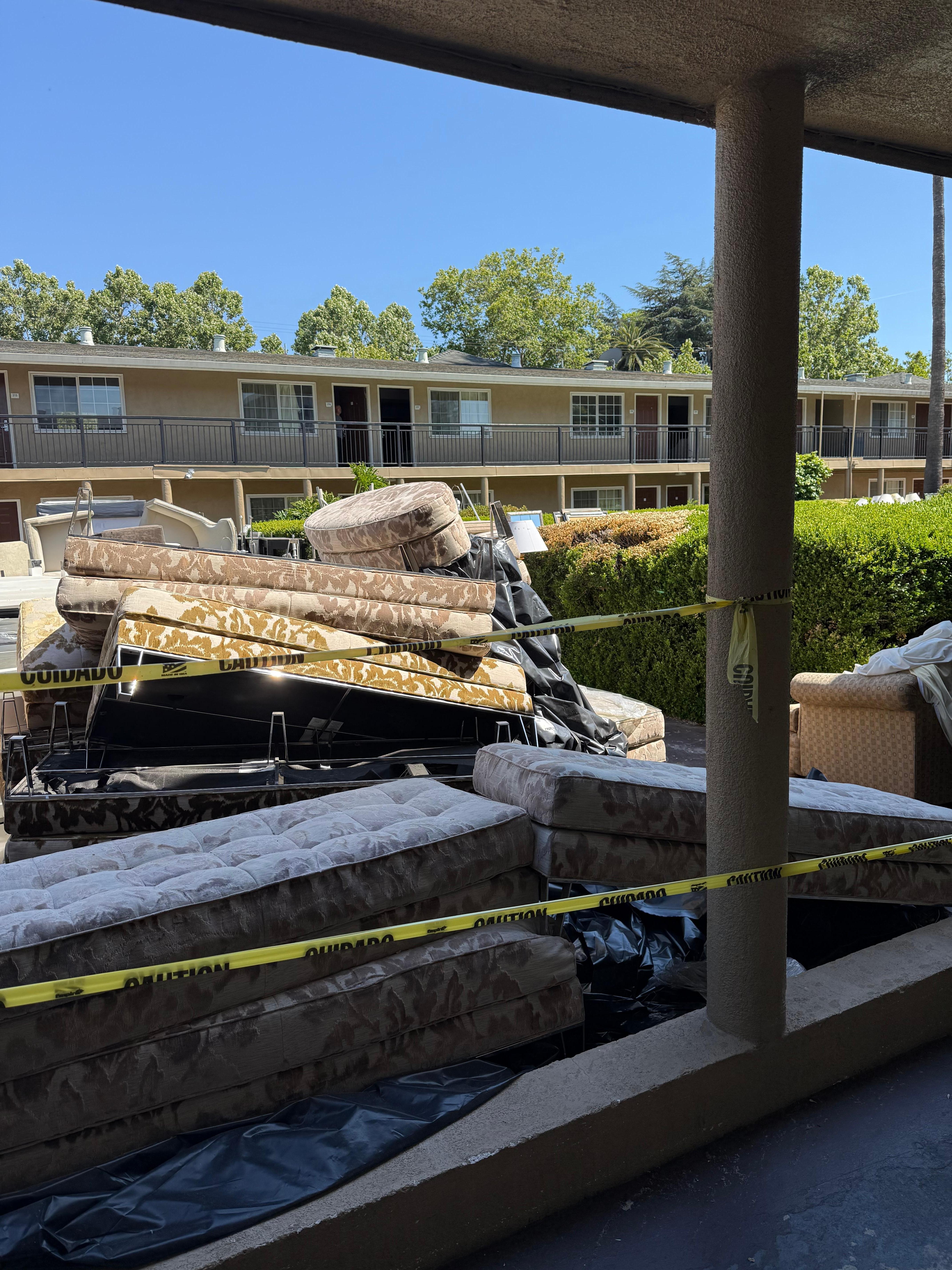 More hotel furniture, being the bushes is where the pool is. It’s gated with additional furniture surrounding it.