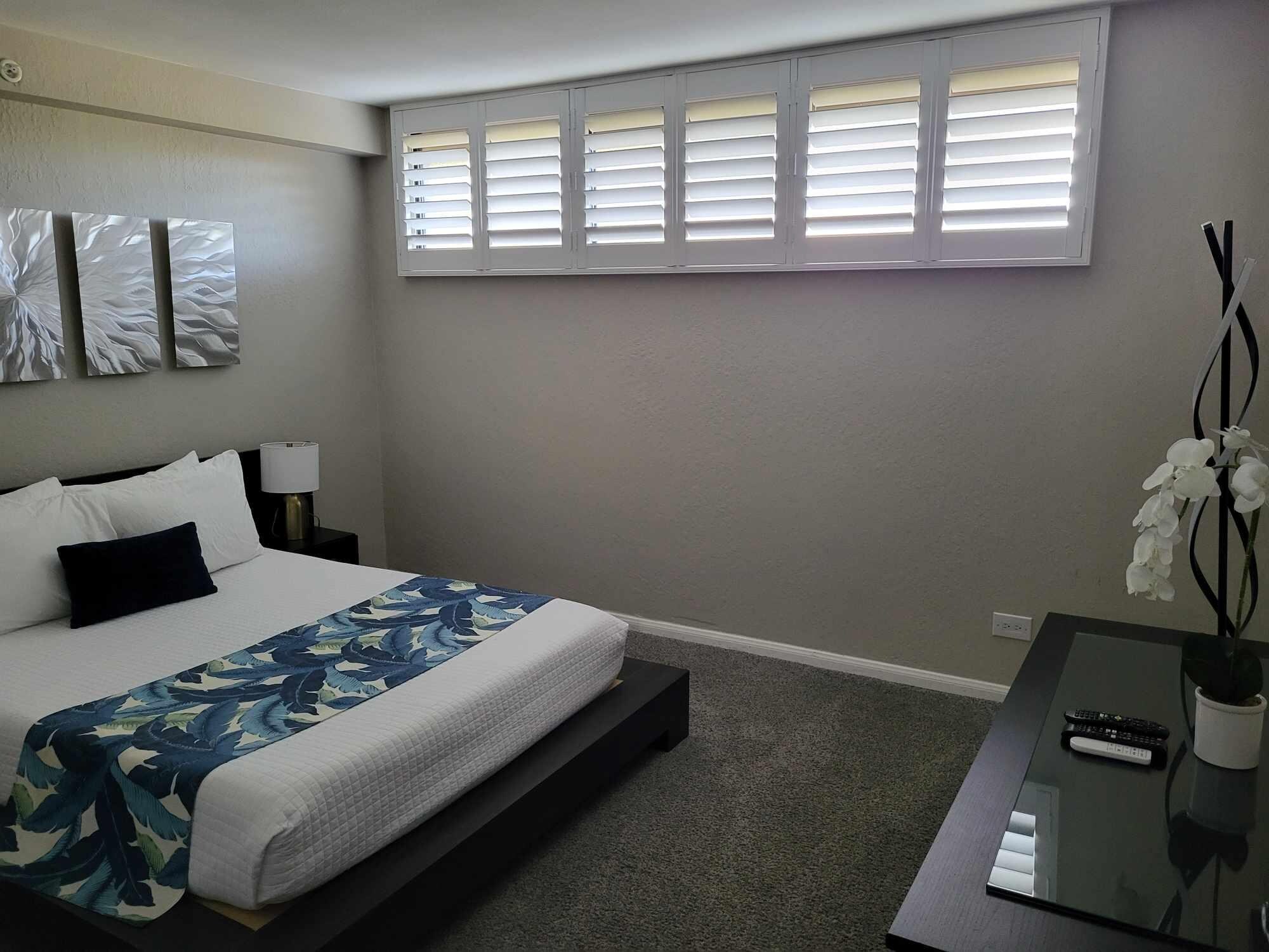 Spacious master bedroom. Bed is low to the ground with cool lighting underneath.