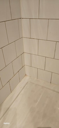 Yellowing tile grout in the shower cubicle.