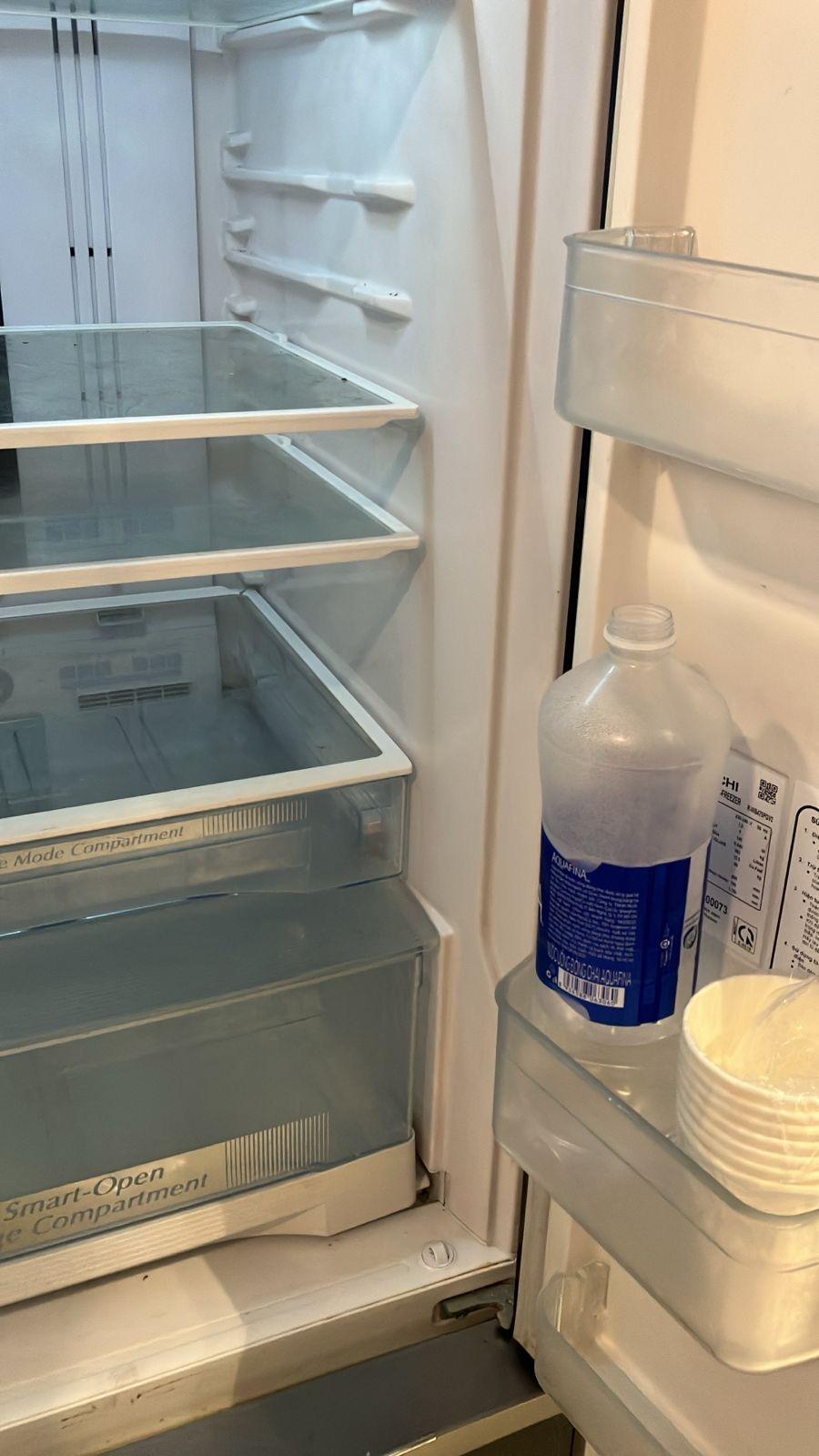 Fridge dirty with bottle of water open