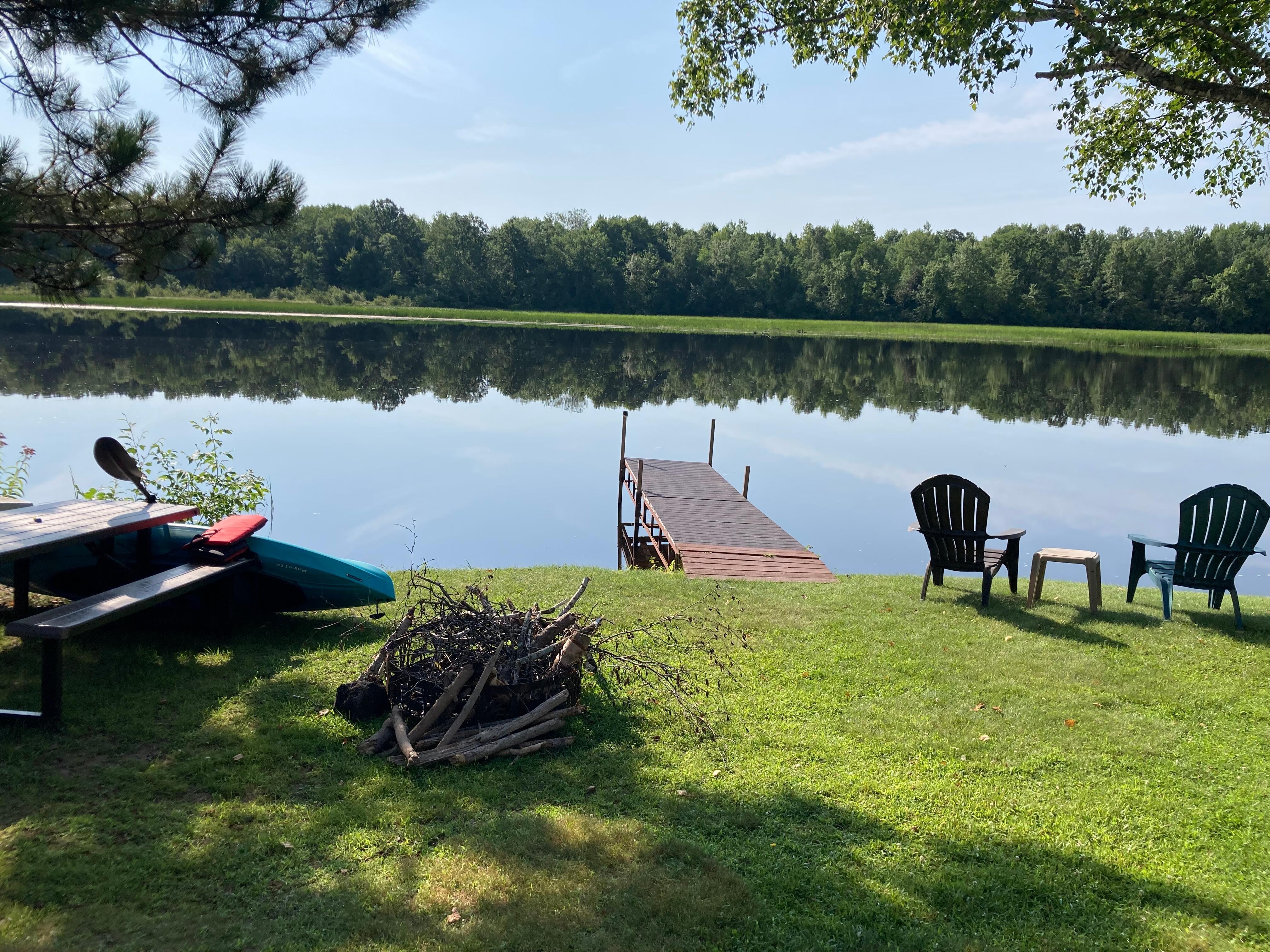 View from the Cabin #2 of the pier, picnic table,  chairs and the flowage, 
