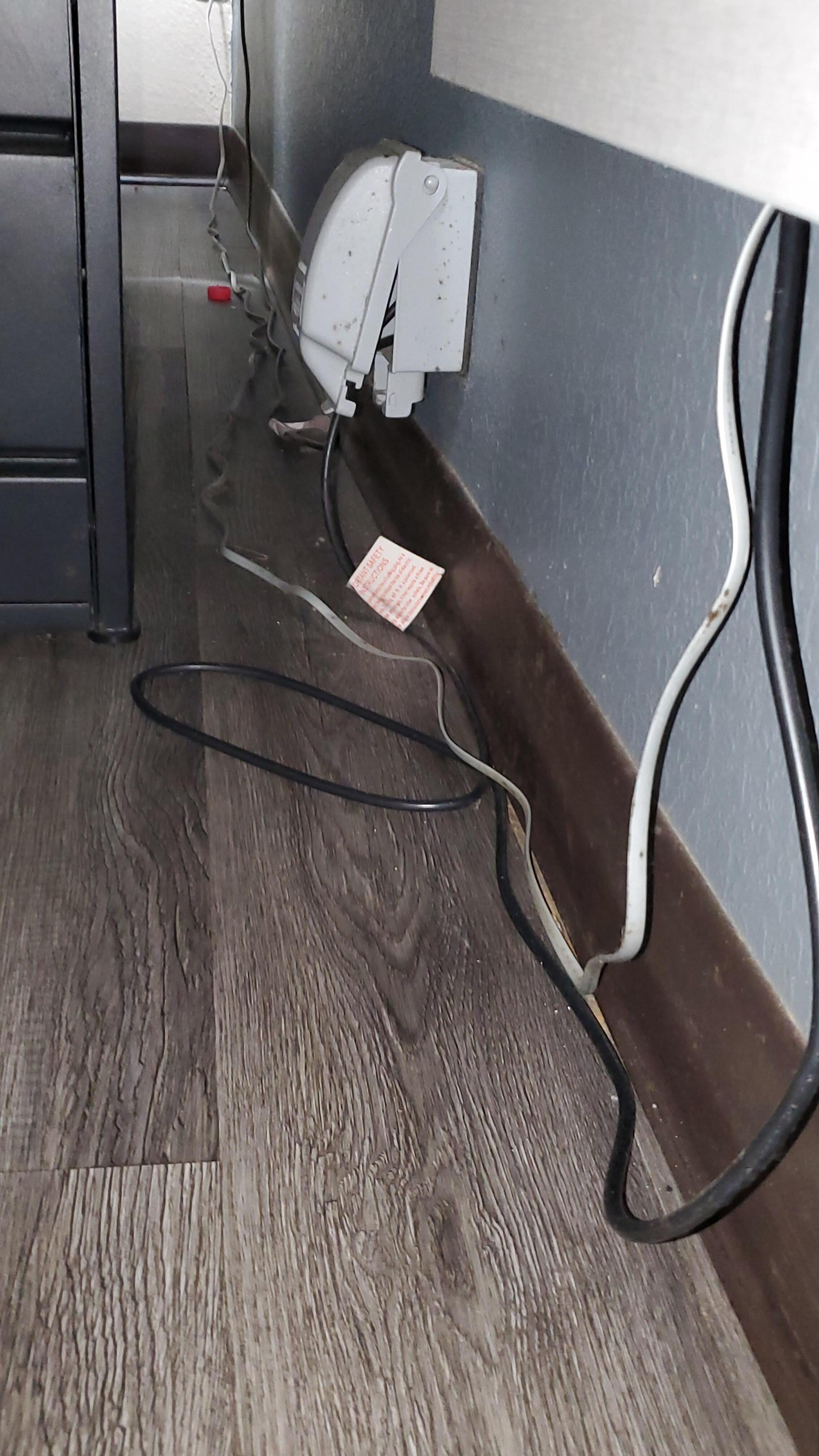 Trash and dirt behind the bed. 