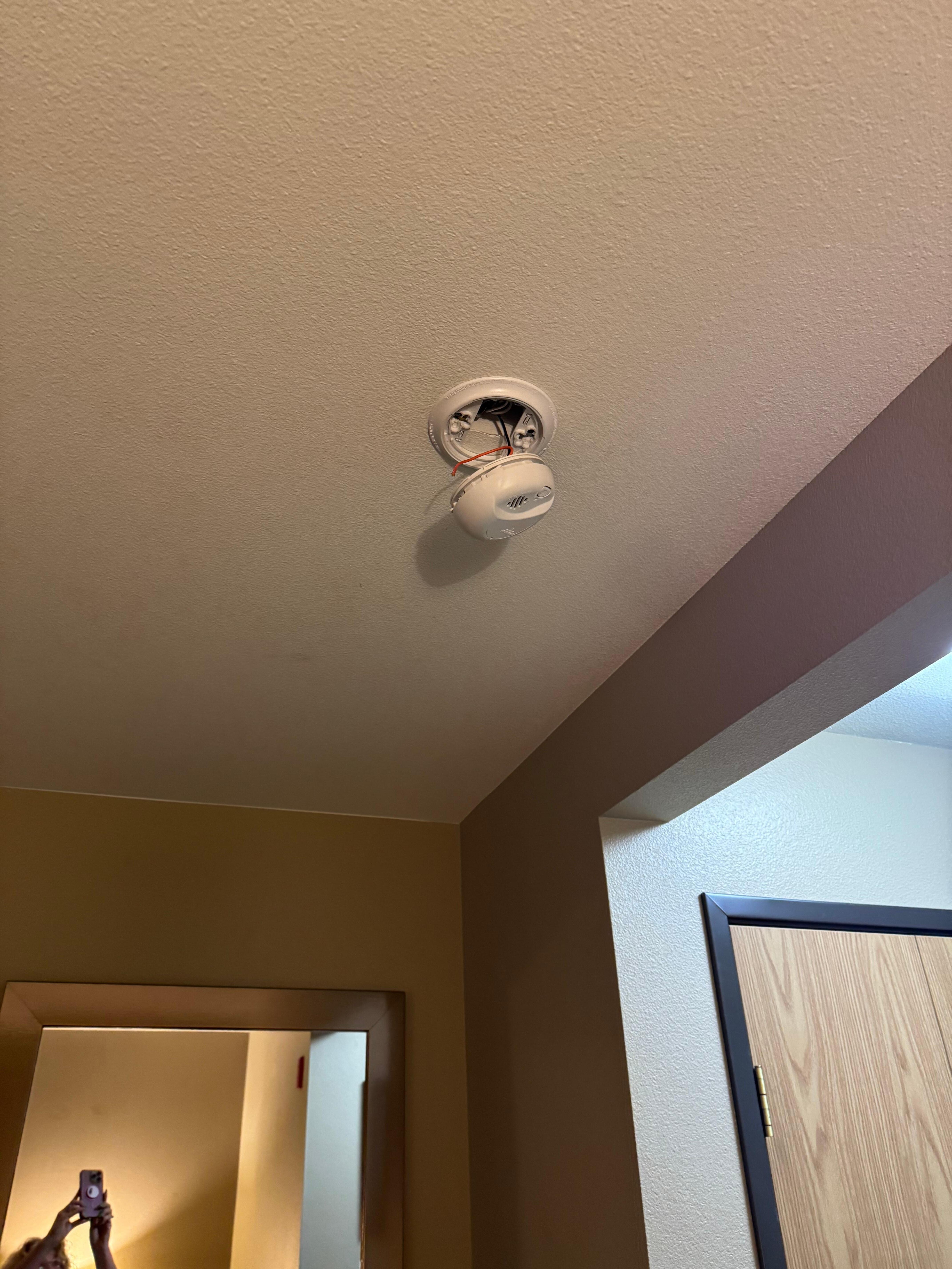 Smoke detector hanging from ceilinb