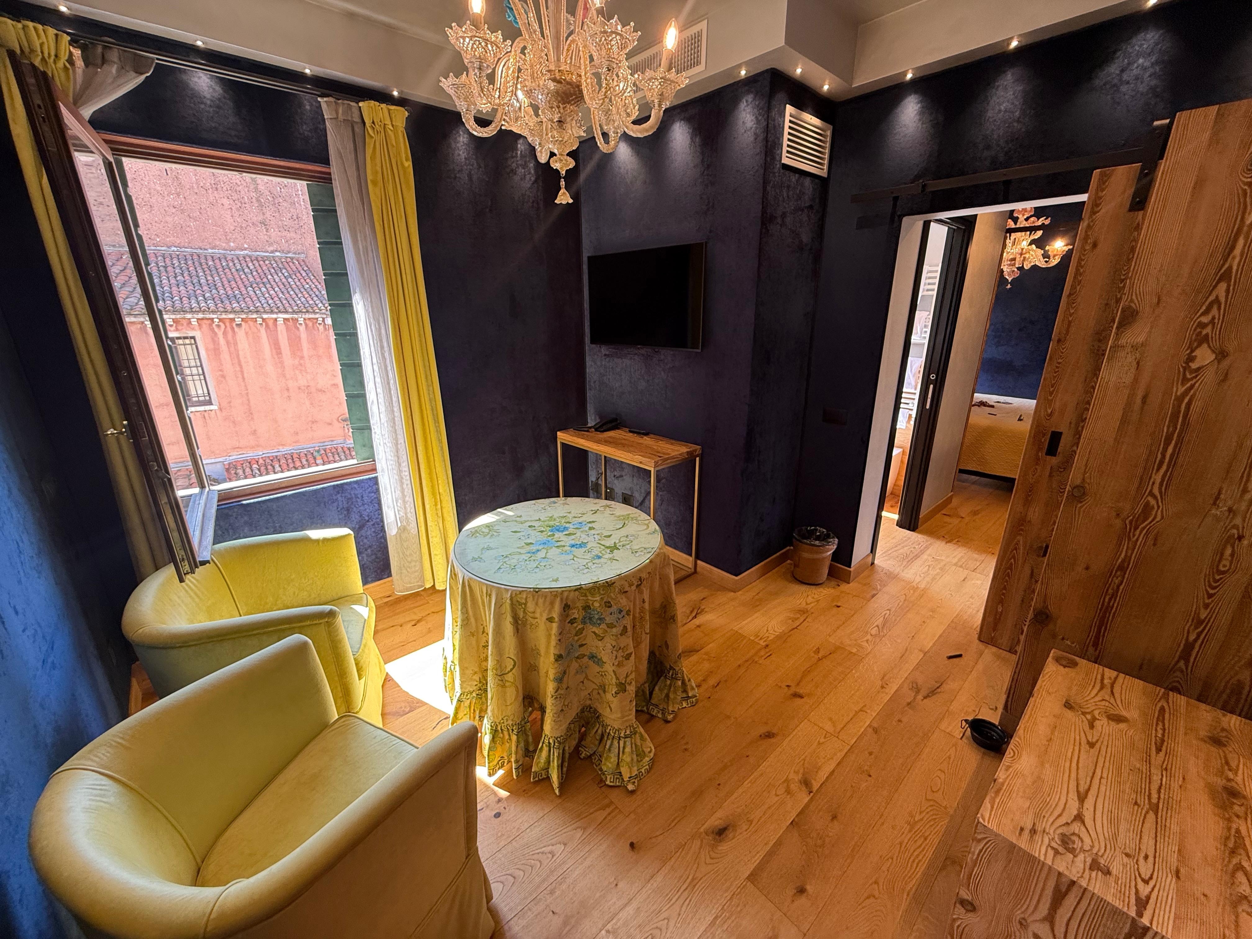 Living room area with TV and lovely lighting.  I love all the sliding doors that you can create privacy within a hotel room.