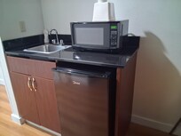 A fantastic mini microwave and a mini fridge with a sink with running water.